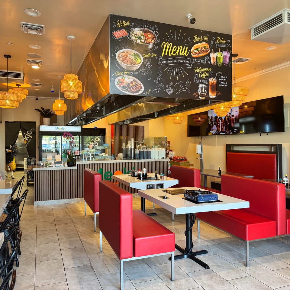 Meokja dining room with red booths and warm pendant lights.